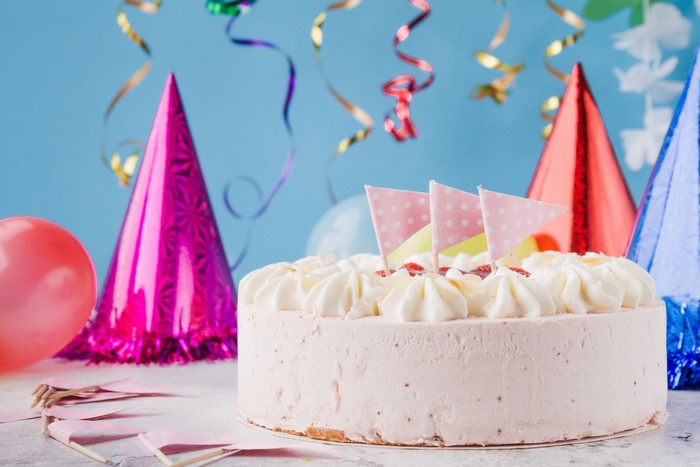 Birthday cake with party hats and streamers