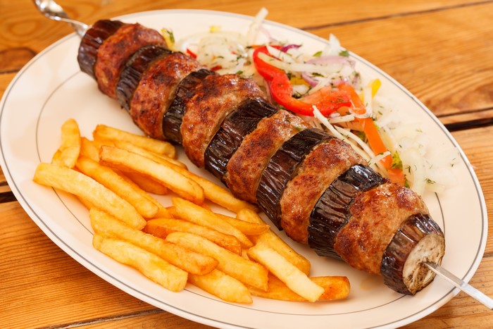 Kebab with eggplant and french fries on a plate
