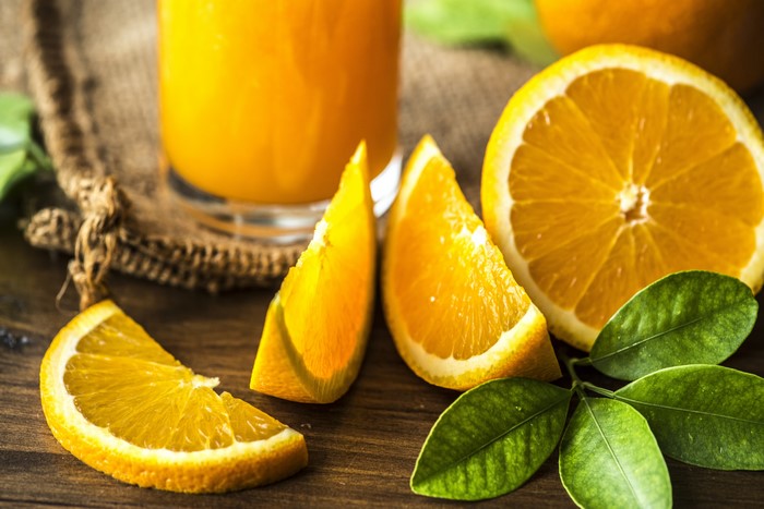 Orange juice with orange slices and leaves