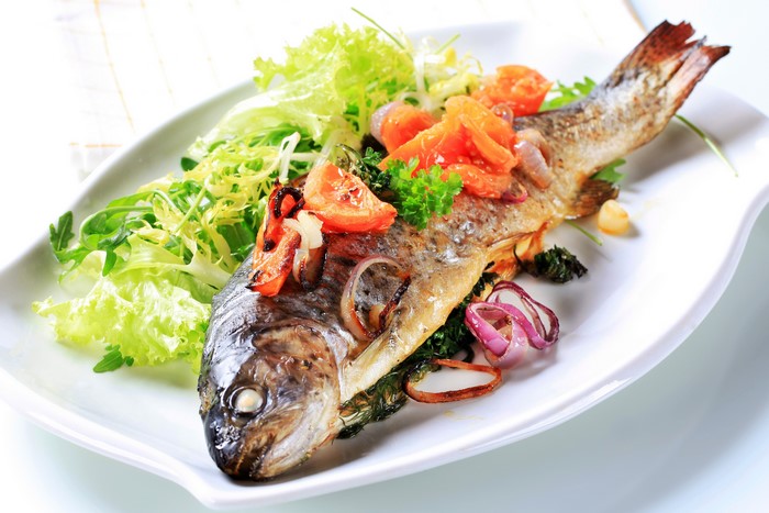 Whole roasted fish with salad and vegetables