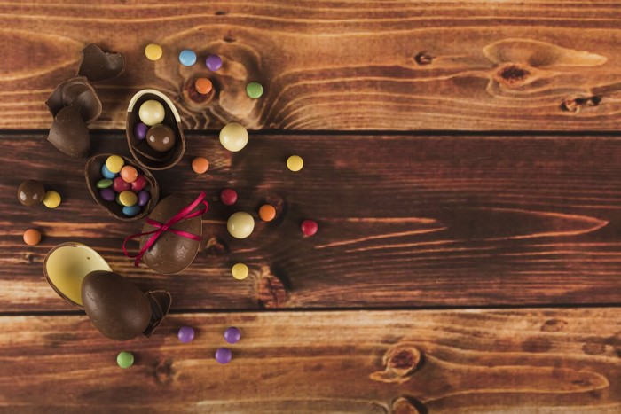 Easter chocolate eggs and candies on wood planks