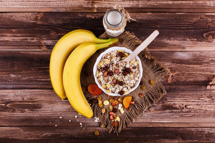 Bananas, Muesli, and Milk on Wood Planks
