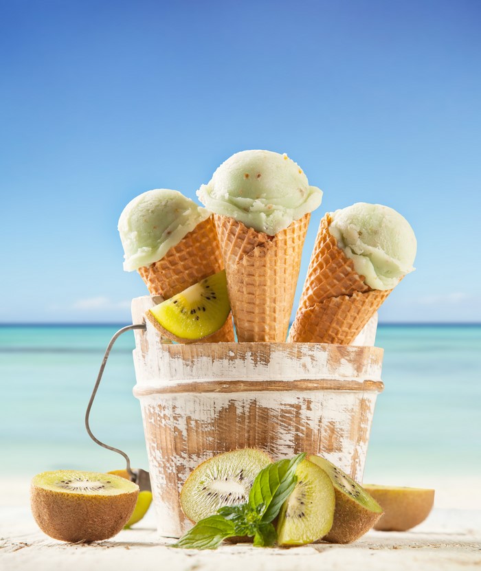 Kiwi ice cream cones in a bucket on a beach