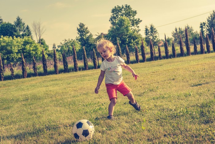 Young girl playing soccer on a grassy field