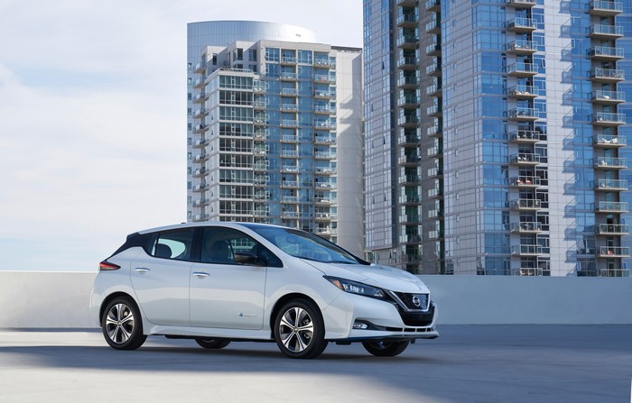 White 2019 Nissan Leaf e parked in front of modern buildings