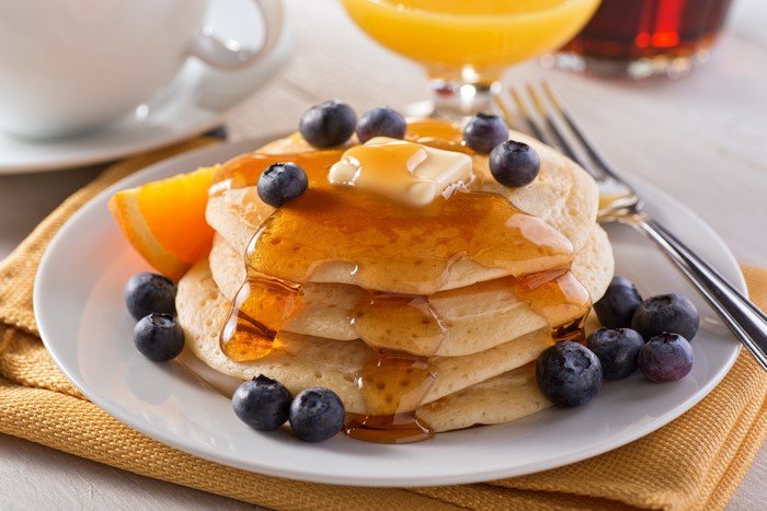 Pancakes with blueberries and honey on a plate