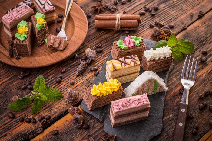 Assortment of small cakes with coffee beans and cinnamon sticks