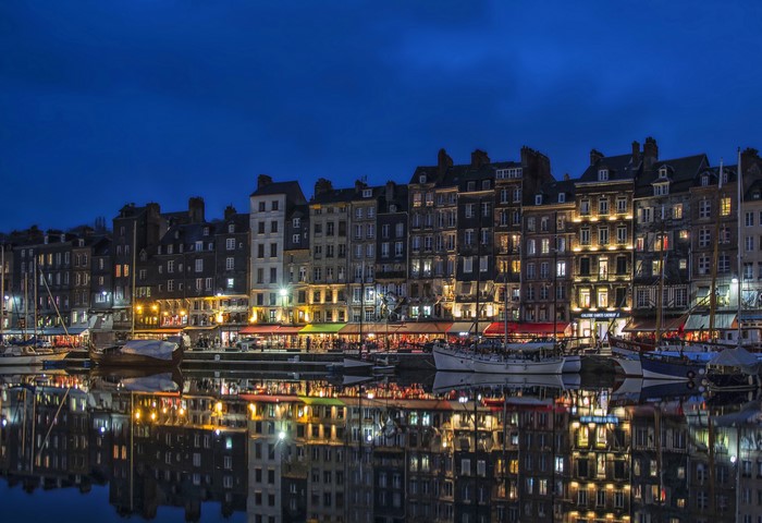Honfleur harbor with buildings and boats at dusk