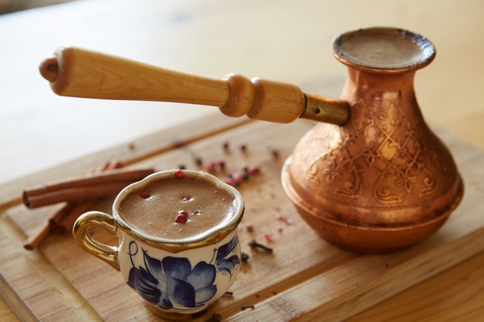 Coffee cup and cezve with cinnamon sticks