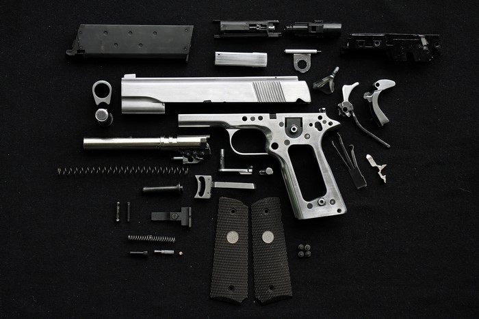 Disassembled Pistol on Black Background
