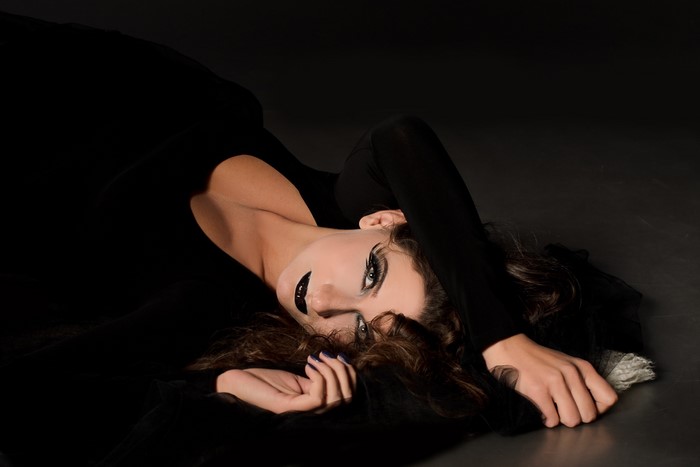 Brunette girl with dramatic makeup lying down