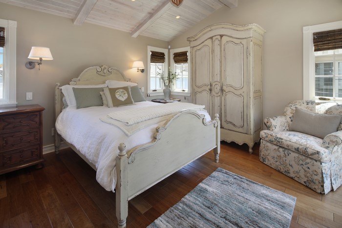 Bedroom with bed, armchair, and armoire