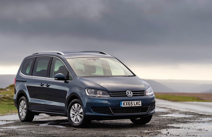Blue Volkswagen Sharan MPV on a wet road