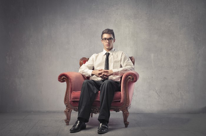 Man with glasses sitting in an armchair