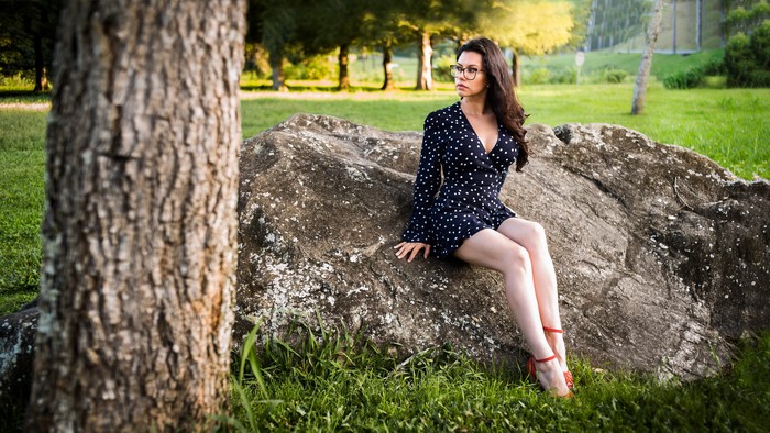 Woman in polka dot dress sitting on a rock
