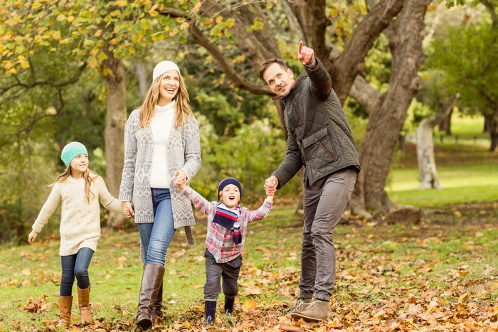 Family strolling in autumn park