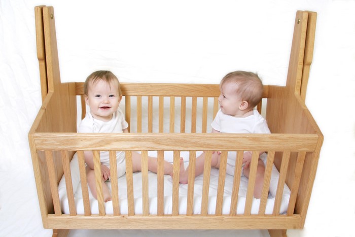 Two babies in a wooden crib