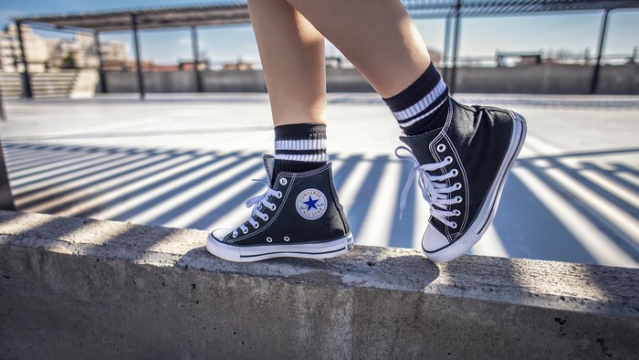 Converse All Star shoes on a person's legs