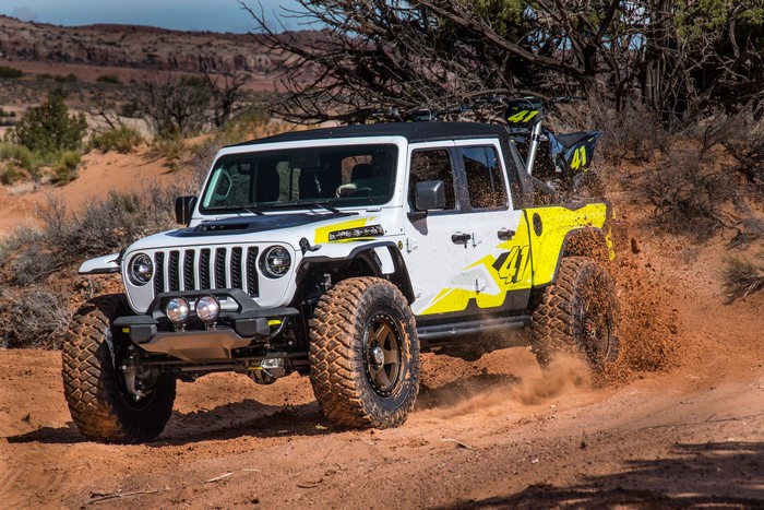 White Jeep Gladiator with yellow graphics off-roading