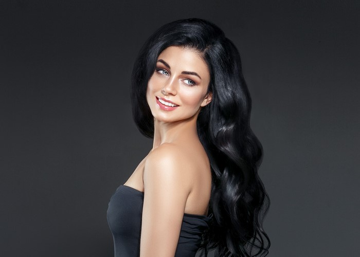 Brunette woman with long wavy black hair smiling
