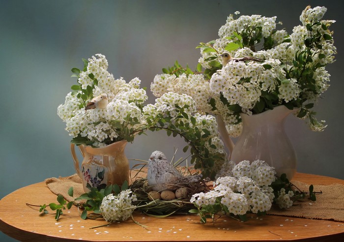 Still life with birds, nest, eggs, and flowers in vases