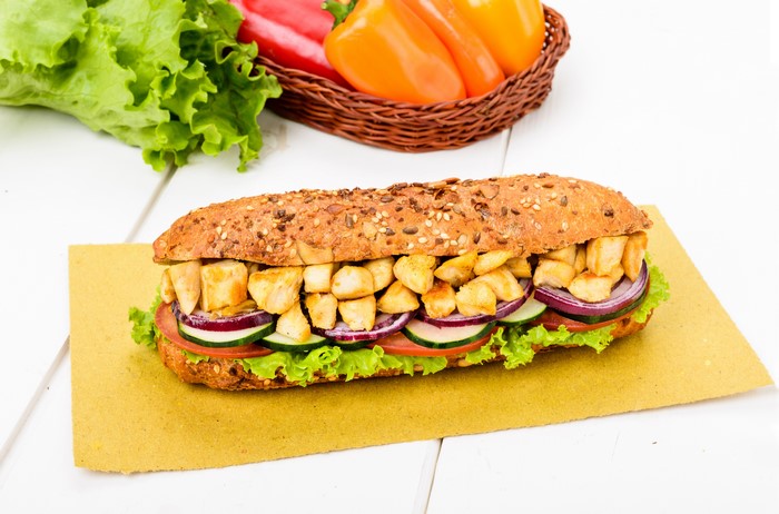Sandwich with chicken, vegetables, and seeds