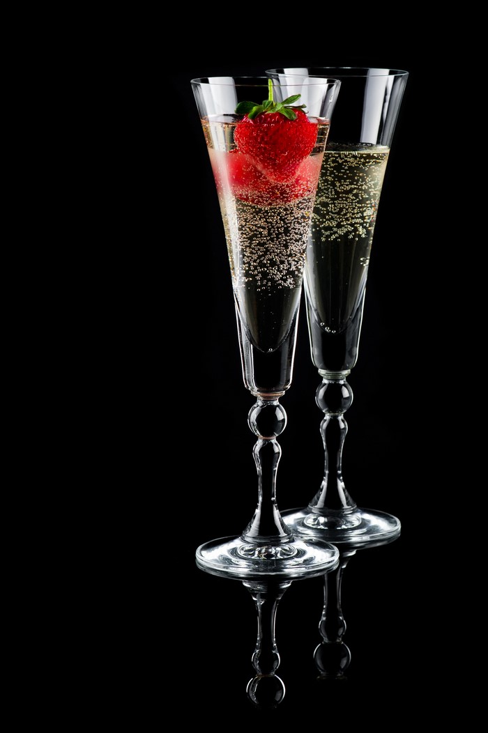 Two champagne flutes with strawberries