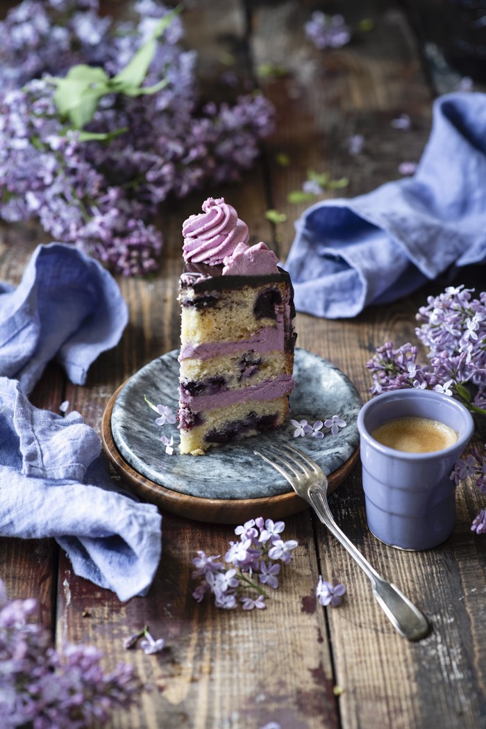 Slice of cake with coffee and lilacs