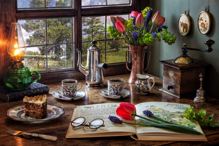 Still-life with tulips, coffee, and cake by a window