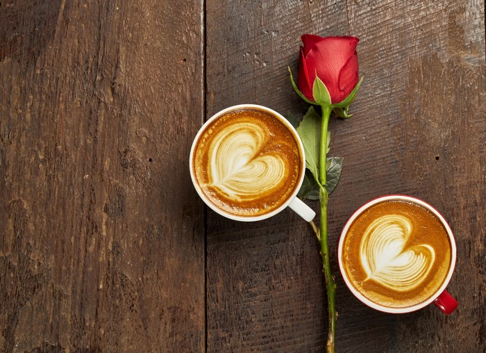 Two heart-shaped lattes and a red rose