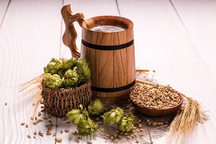 Beer mug with hops and barley on wood planks