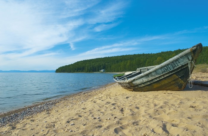 Old boat on the sandy shore of a lake in Siberia, Russia