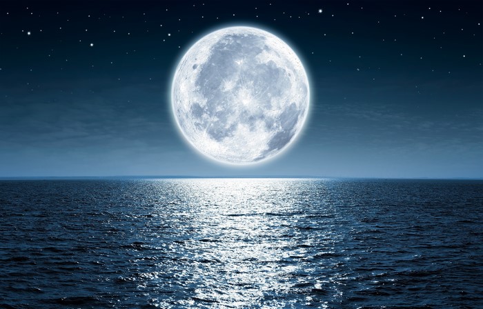 Full moon over the ocean at night