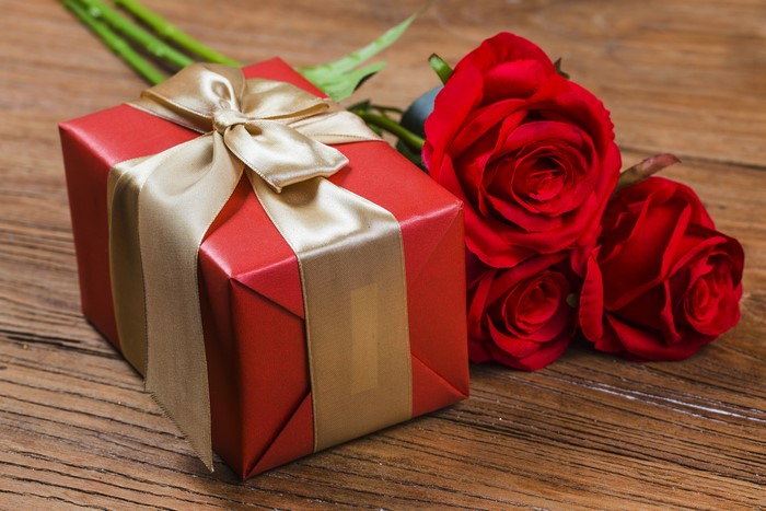 Red gift box with golden ribbon and red roses