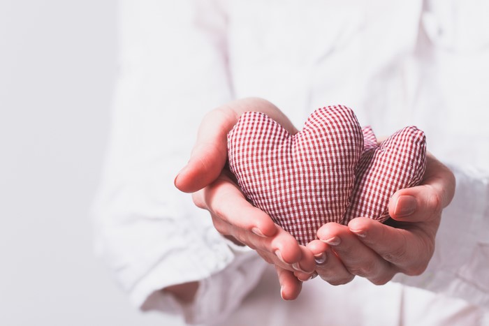 Hands holding two checkered hearts
