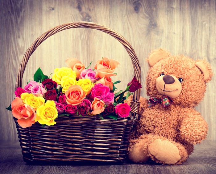 Teddy bear with roses in a wicker basket
