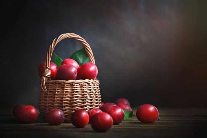 Red Plums in a Wicker Basket