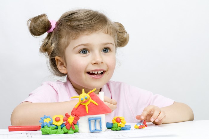 Little girl playing with clay toys