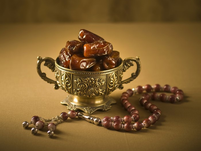 Dates in a decorative bowl with prayer beads