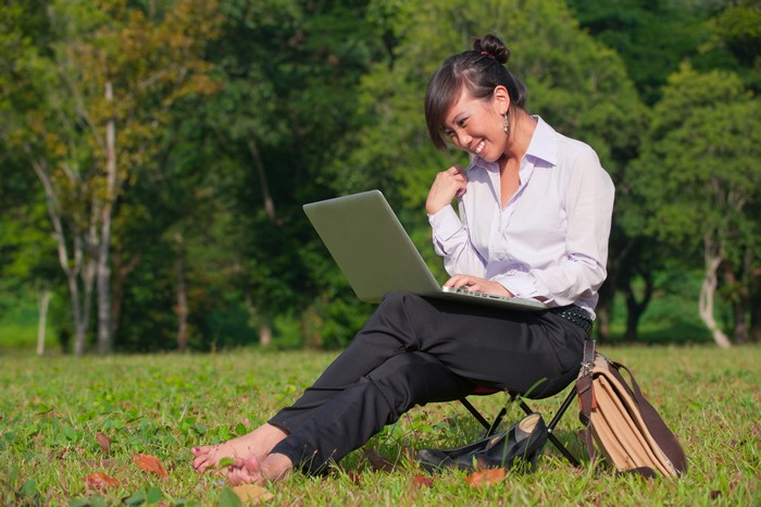 Asian woman working on a laptop outdoors