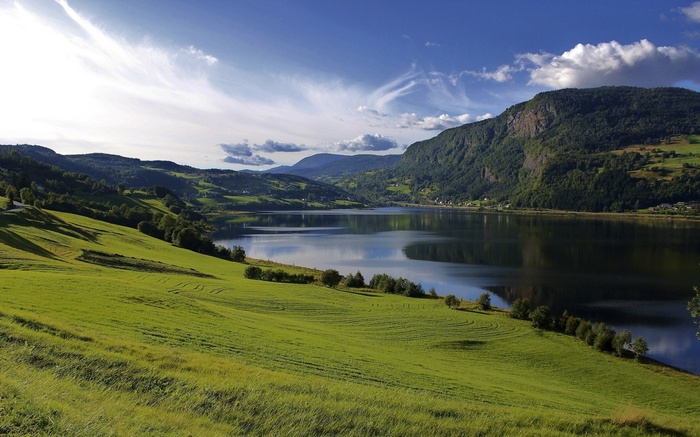 Green rolling hills and a lake in Norway
