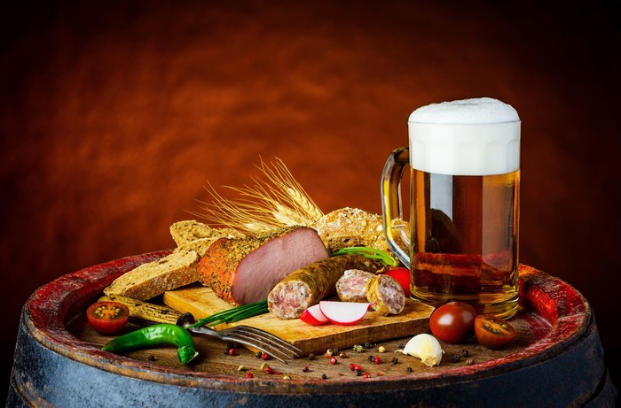 Beer, Sausage, Ham, and Bread on a Barrel