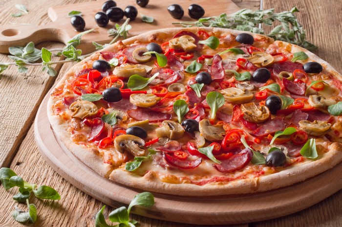 Pizza with Sausage, Olives, and Mushrooms on Cutting Board