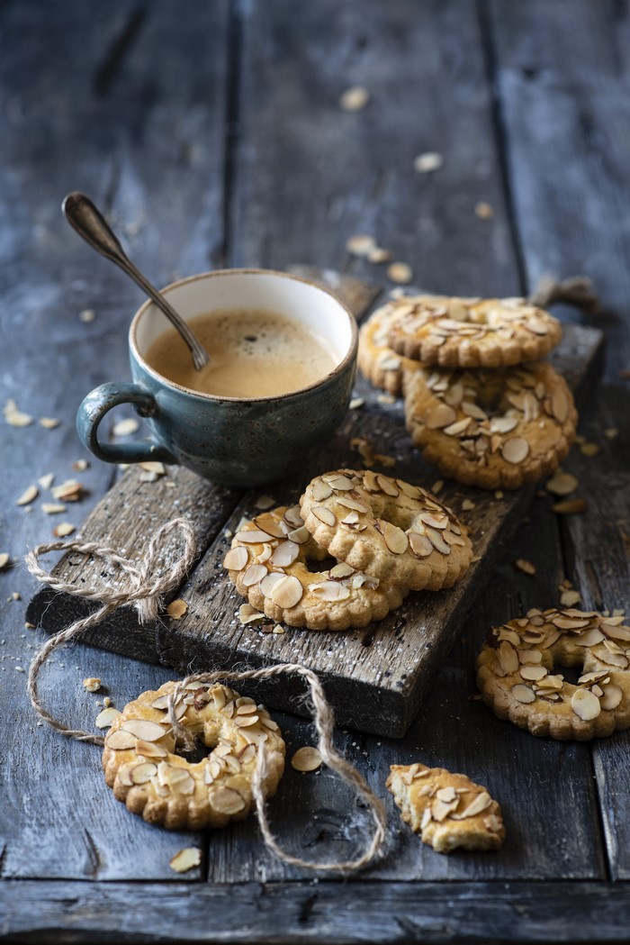 Almond cookies and coffee on a wooden board