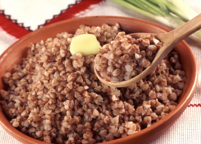 Buckwheat porridge with butter on a spoon