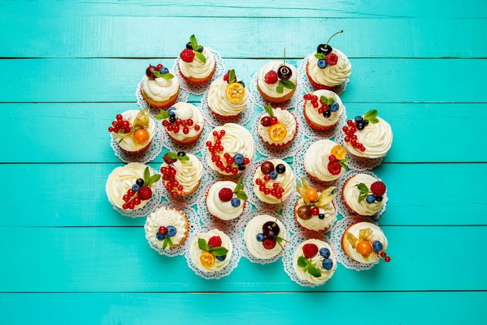 Assortment of colorful cupcakes with berries and fruits