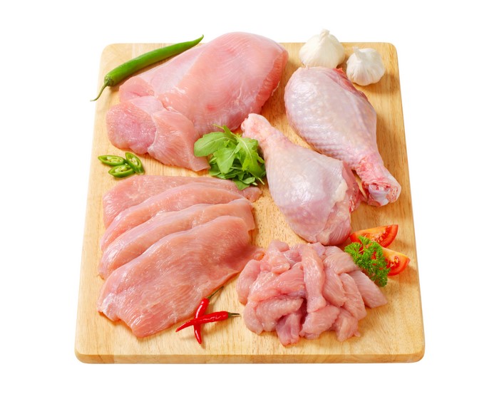 Raw Turkey Meat Cuts with Vegetables on Cutting Board