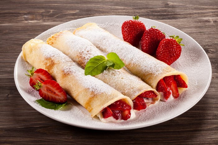Pancakes with strawberries and powdered sugar on a plate