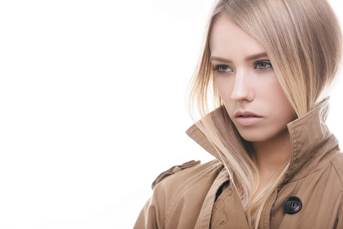 Woman with dark blonde hair in a trench coat