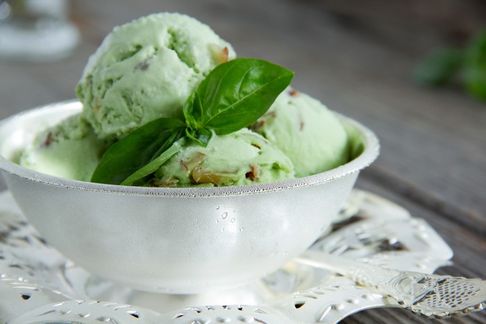 Green ice cream scoops in a bowl with basil
